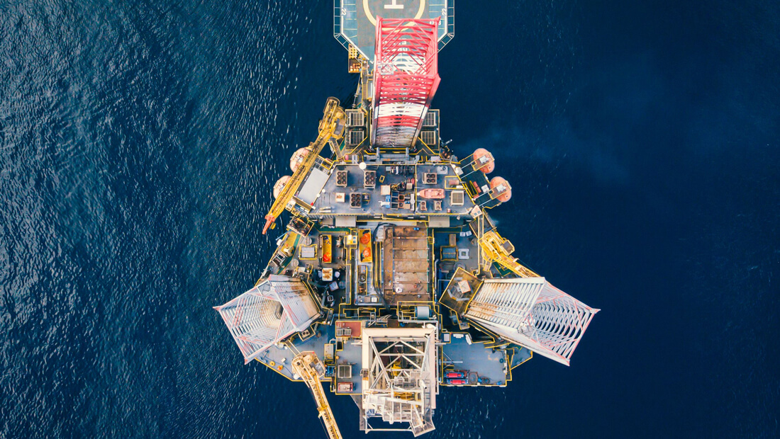 Aerial view of an offshore oil drilling platform in the ocean.