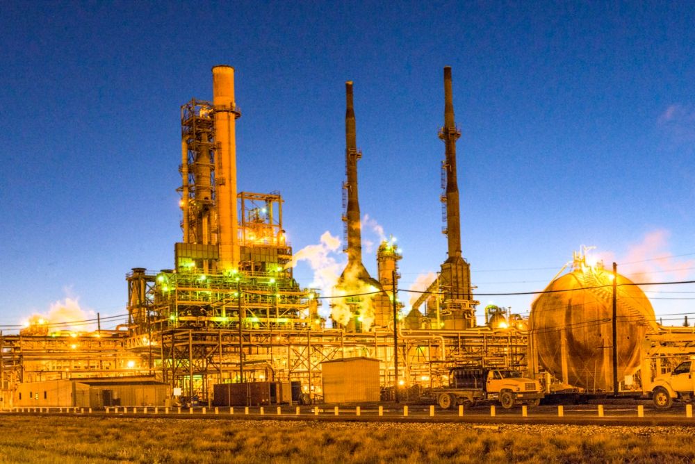 Industrial plant with illuminated structures at dusk.