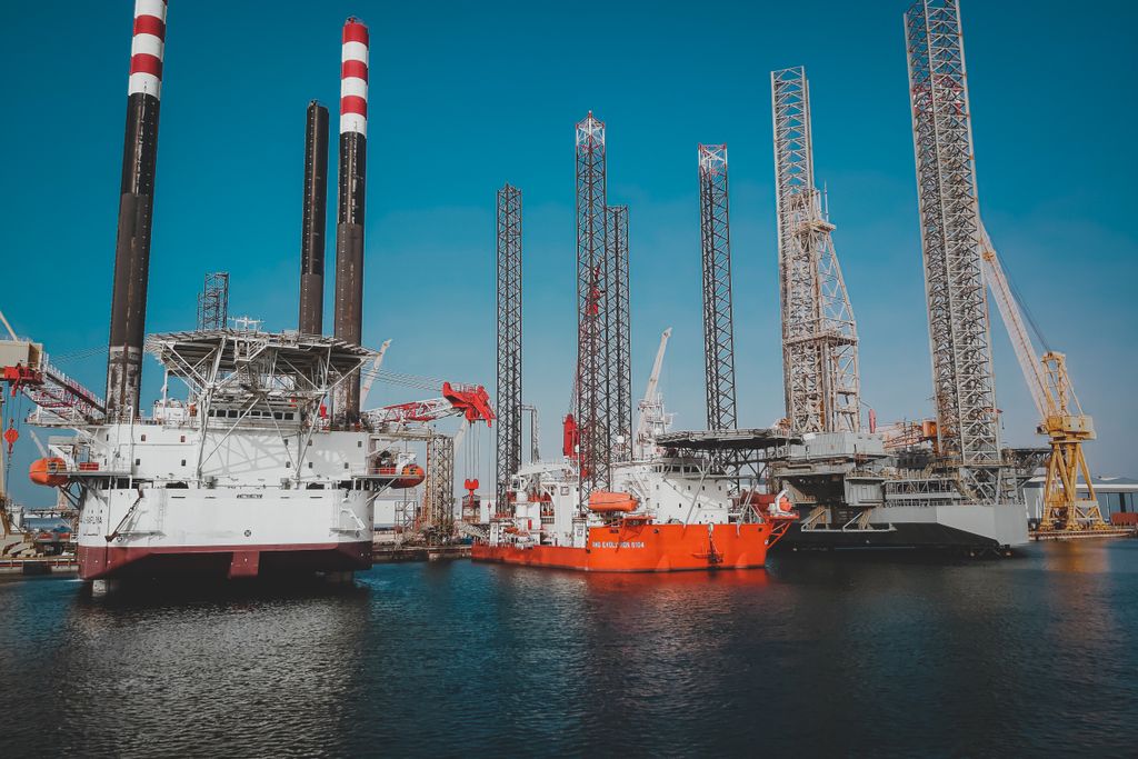 Offshore drilling platform and vessels at a harbor.